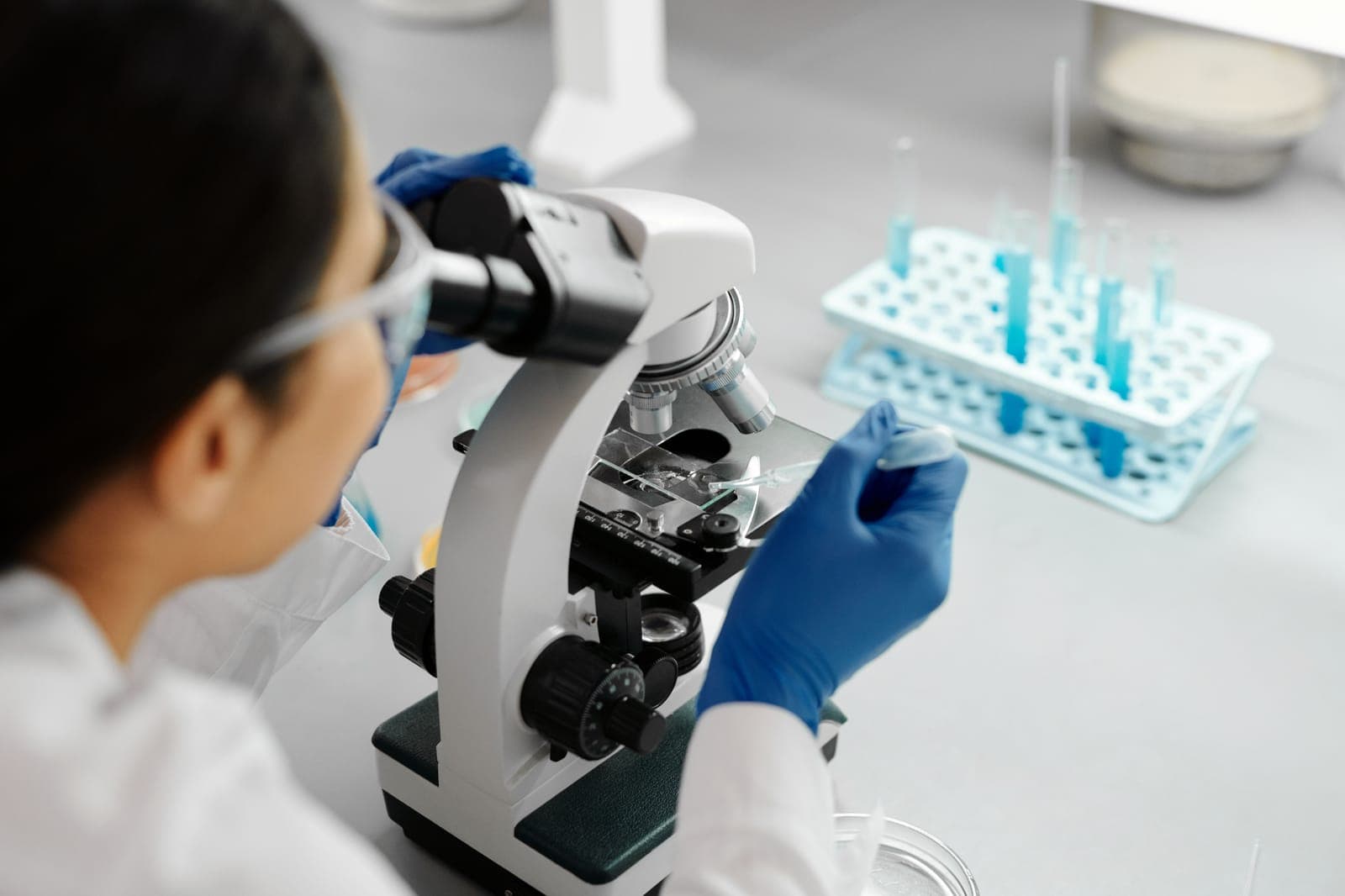 Investigadora observando una muestra al microscopio en un laboratorio